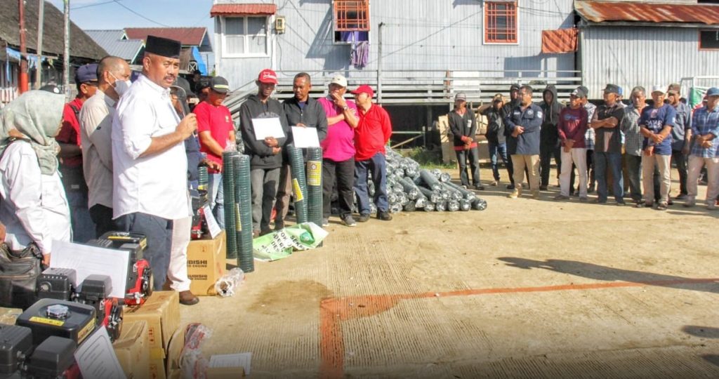 Bupati Edi Damansyah menyerahkan bantuan nelayan  kepada kelompok nelayan, di Lapangan Tugu Muara Kaman, Minggu, 16 Oktober 2022. [Ist]