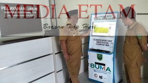 Wabup Berau, Gamalis (mengenakan peci) bersama Kepala Kampug Merancang Ilir, Zulfikar, saat melihat perangkat aplikasi layanan mandiri milik masyarakat kampung. [Prokopim Setkab Berau / Mediaetam.com]