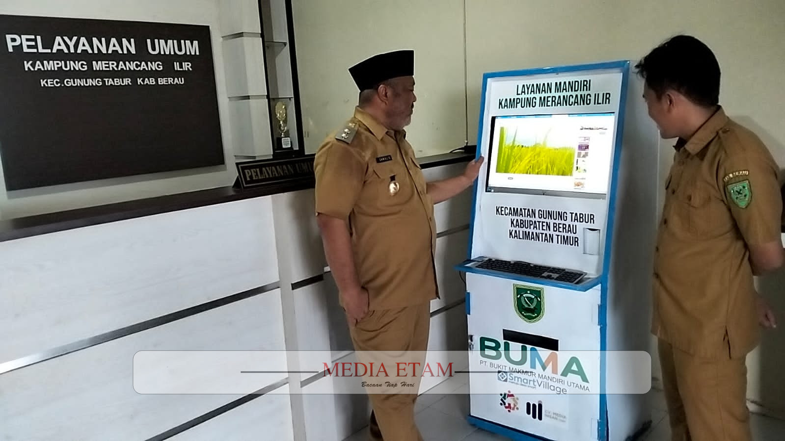 Wabup Berau, Gamalis (mengenakan peci) bersama Kepala Kampug Merancang Ilir, Zulfikar, saat melihat perangkat aplikasi layanan mandiri milik masyarakat kampung. [Prokopim Setkab Berau / Mediaetam.com]