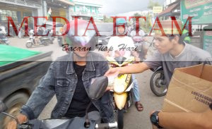 Salah satu pemuda Karang Taruna Gunung Panjang tengah memberikan paket takjil kepada masyarakat. [Christian / Mediaetam.com]
