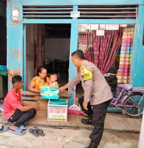 Personel Polsek Loa Kulu Saat memberikan bantuan kepada keluarga yang memiliki balita (Foto Istimewa)