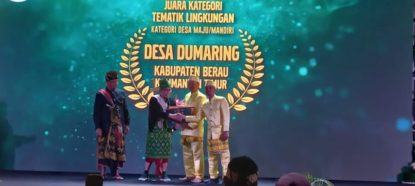 Kepala DPMK Berau, Tentram Rahayu saat menerima penghargaan dari Kemendes RI.