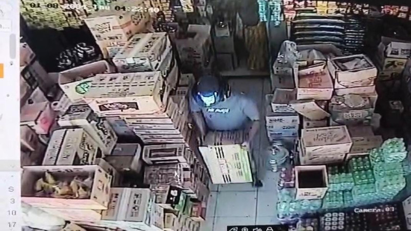 Pelaku berbadan gempal membawa kardus berisi rokok keluar dari toko (Doc.CCTV Toko Sembako)