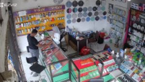 Pelaku berbadan gempal berbaju warna hitam sedang melihat hp di toko Yumna Store Jalan Kartini, Tenggarong (Doc. Yumna Store CCTV)